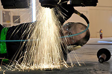 image of a man performing repairs on the underside of a car