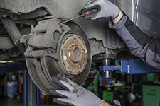 image of a man servicing a cars breaks